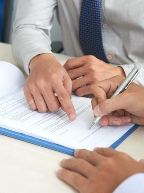 Businessman showing his partner where to sign the contract